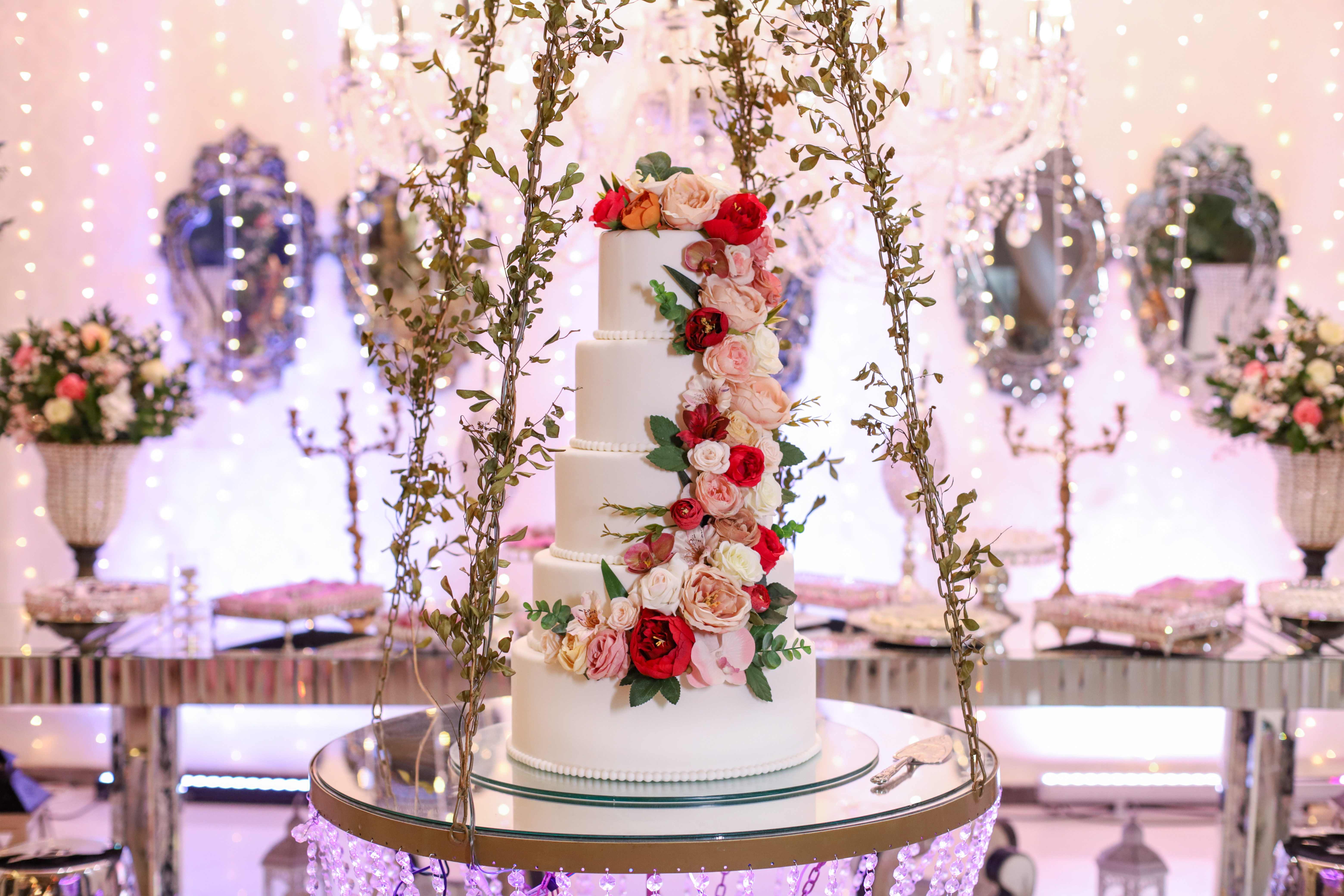 Mesa do bolo com cascata floral imponente